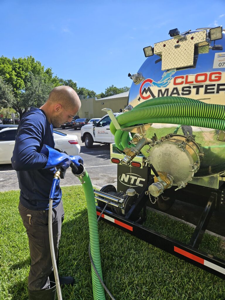 Why Drains Clog in Hollywood, FL Homes (and How to Prevent It) 1 Technician clearing a drain line with a high-pressure hose